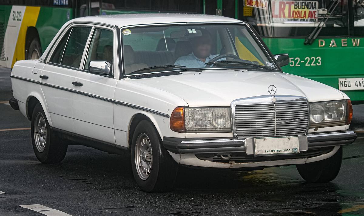 Bílý čtyřdveřový Mercedes-Benz 300 D řady 123 zepředu z boku
