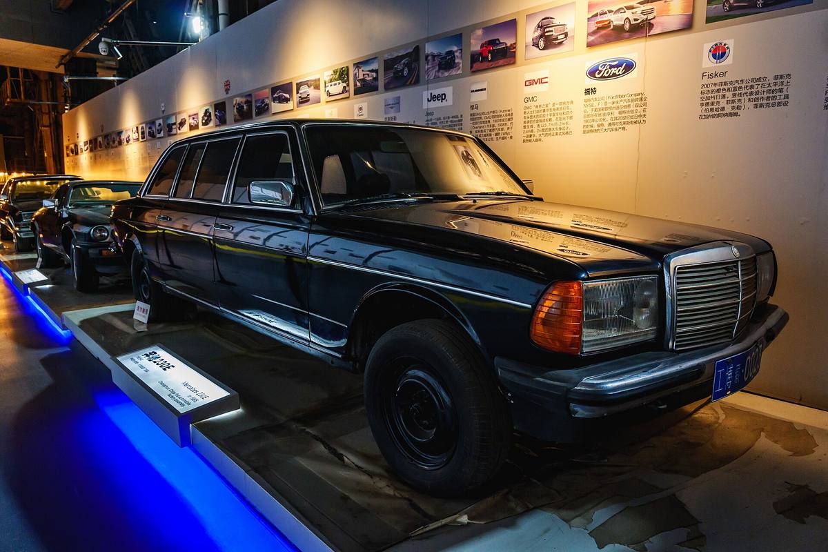 Černý prodloužený sedan Mercedes-Benz 230 E s modrou čínskou poznávací značkou v muzejní expozici