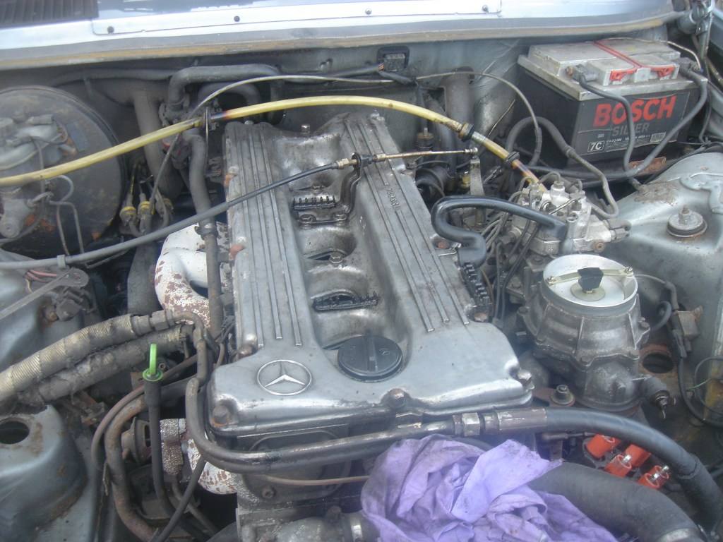 Motor M110 pod otevřenou kapotou Mercedesu W123 280E