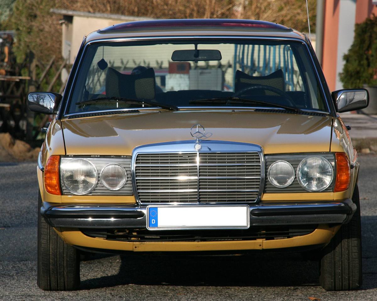 Sedan Mercedes-Benz 230 řady 123 z roku 1977 zepředu, za čelním sklem jsou vidět přední opěrky hlavy
