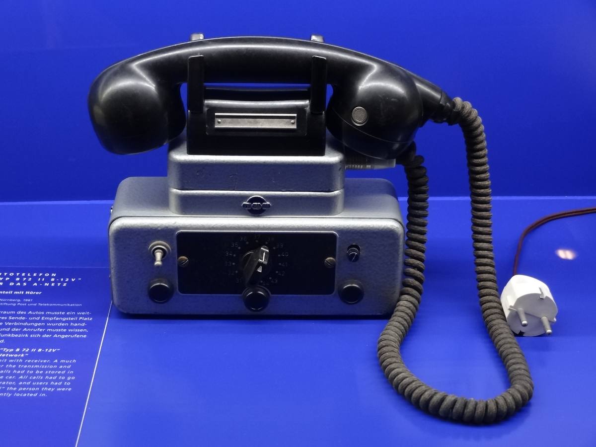 Vozidlový telefon TeKaDe se sluchátkem a ovládací skříňkou ve vitríně muzea