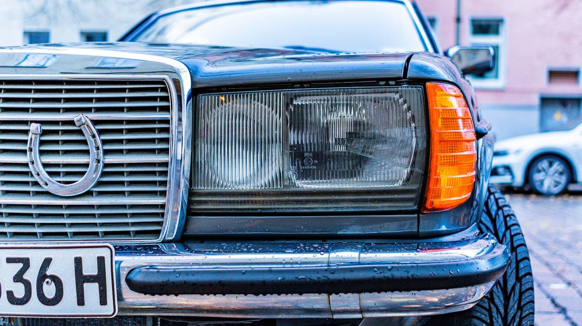 Přední část staršího Mercedesu s německou registrační značkou, která končí písmenem H