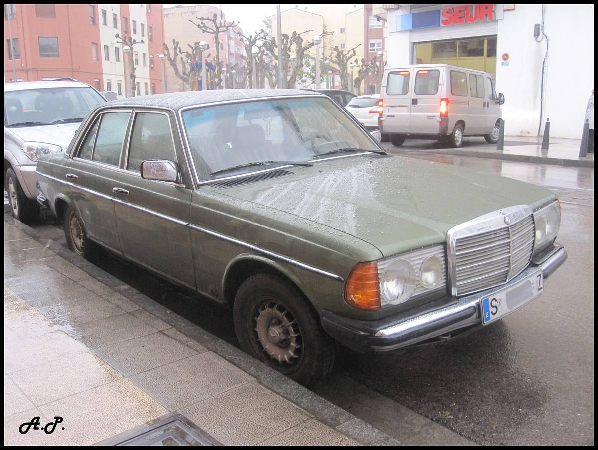 Tmavý sedan Mercedes-Benz 300 D řady 123 zaparkovaný u chodníku