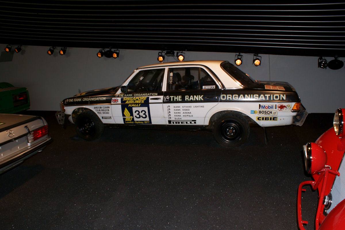 Rallyový sedan Mercedes-Benz 280 E řady W123 z maratonu Londýn–Sydney 1977 v muzeu Mercedes-Benz, pohled zleva
